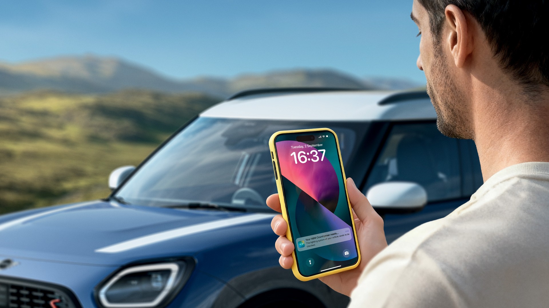 A man sitting in a MINI looking at his phone